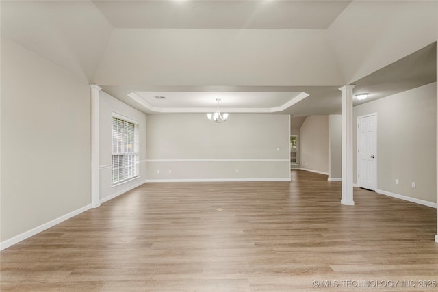 4309 W College St, Broken Arrow, OK 74012 - unfurnished living room featuring a tray ceiling, light wood-style floors, baseboards, and decorative columns