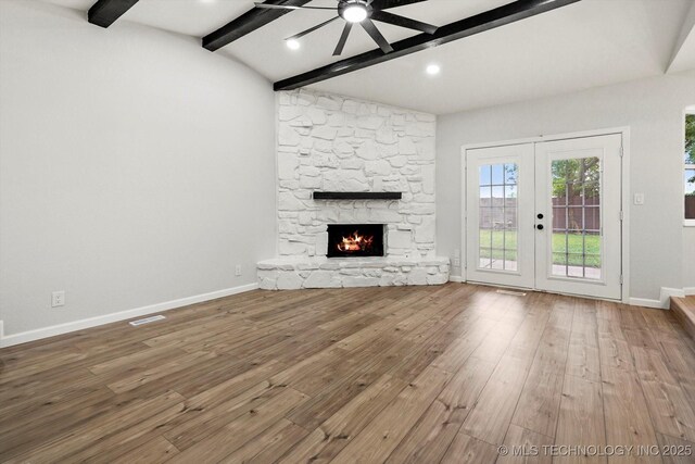 10128 E 34th St, Tulsa, OK 74146 - unfurnished living room with ceiling fan, french doors, hardwood / wood-style flooring, baseboards, and a stone fireplace