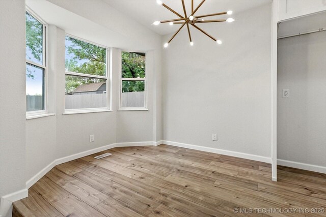10128 E 34th St, Tulsa, OK 74146 - unfurnished room with light wood finished floors, baseboards, and a chandelier