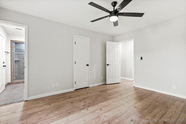 10128 E 34th St, Tulsa, OK 74146 - unfurnished bedroom featuring wood finished floors, baseboards, and ensuite bathroom