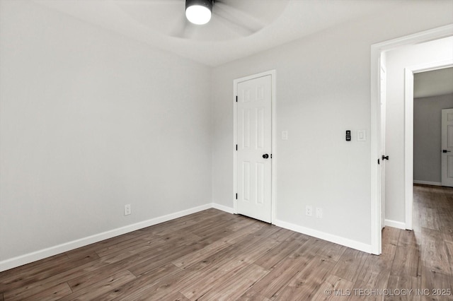 10128 E 34th St, Tulsa, OK 74146 - unfurnished bedroom featuring wood finished floors, baseboards, and a ceiling fan