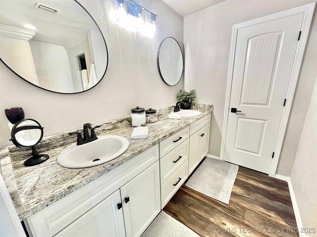 175 Johnson Rd, Broken Bow, OK 74728 - bathroom featuring wood finished floors, double vanity, and baseboards