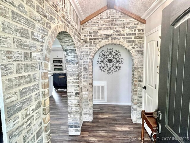 175 Johnson Rd, Broken Bow, OK 74728 - foyer with arched walkways, vaulted ceiling, wood finished floors, baseboards, and crown molding