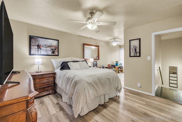 6356 S 80th E Ave Unit 25C, Tulsa, OK 74133 - bedroom with light wood-style floors, a textured ceiling, ceiling fan, and baseboards