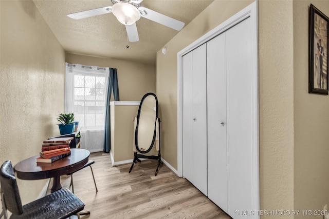 6356 S 80th E Ave Unit 25C, Tulsa, OK 74133 - living area featuring a ceiling fan, light wood-style flooring, a textured ceiling, and a textured wall