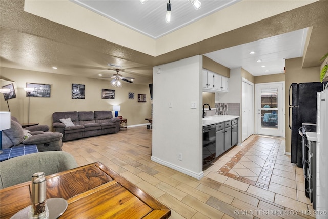 6356 S 80th E Ave Unit 25C, Tulsa, OK 74133 - kitchen with black appliances, light countertops, a sink, baseboards, and a ceiling fan