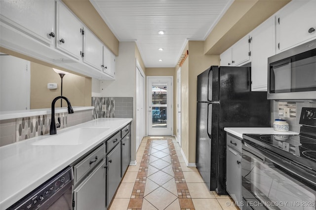 6356 S 80th E Ave Unit 25C, Tulsa, OK 74133 - kitchen with electric range, stainless steel microwave, dishwashing machine, light tile patterned floors, and a sink