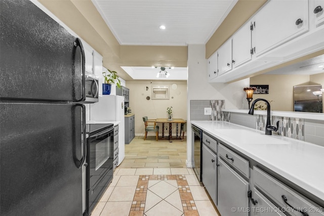 6356 S 80th E Ave Unit 25C, Tulsa, OK 74133 - kitchen with black appliances, a sink, light tile patterned floors, light countertops, and inlaid floor details