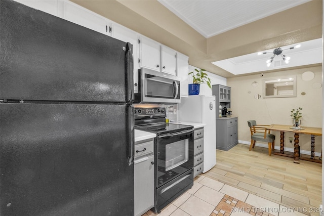 6356 S 80th E Ave Unit 25C, Tulsa, OK 74133 - kitchen with black appliances, light countertops, baseboards, white cabinets, and light tile patterned floors