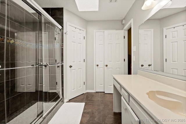 4407 W Lansing Pl, Broken Arrow, OK 74012 - full bathroom with vanity, a stall shower, a skylight, and tile patterned flooring