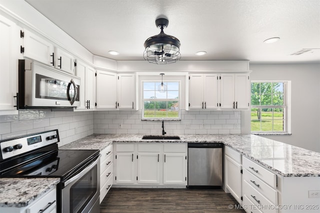 3160 E 406th Rd, Oologah, OK 74053 - kitchen with stainless steel appliances, a sink, a peninsula, white cabinets, and recessed lighting