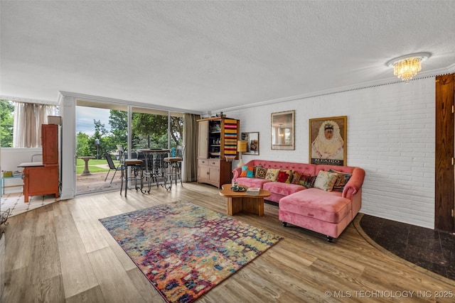611 W 15th St Unit F1, Tulsa, OK 74127 - living room featuring a textured ceiling, wood finished floors, brick wall, and crown molding