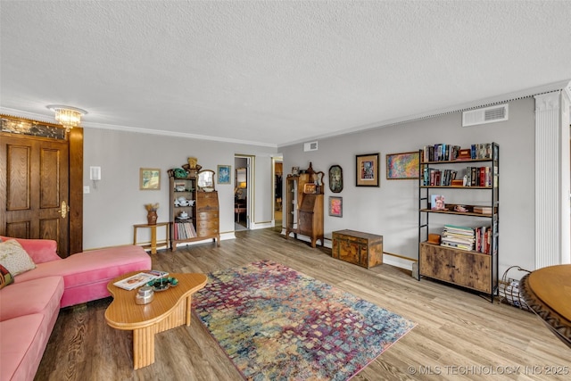 611 W 15th St Unit F1, Tulsa, OK 74127 - living room with a textured ceiling, wood finished floors, crown molding, and baseboards