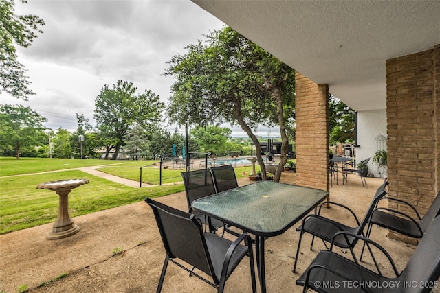 611 W 15th St Unit F1, Tulsa, OK 74127 - view of patio / terrace featuring outdoor dining space and a pool