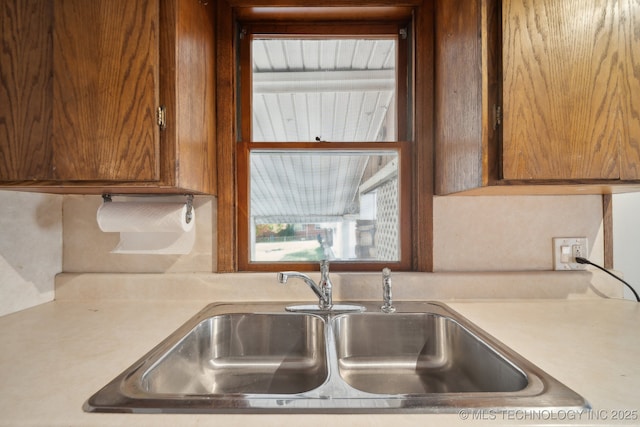 5856 E 22nd St, Tulsa, OK 74114 - kitchen featuring a sink, light countertops, and brown cabinets