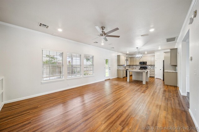 7408 S 94th Ave E, Tulsa, OK 74133 - unfurnished living room with ceiling fan, wood finished floors, recessed lighting, baseboards, and crown molding