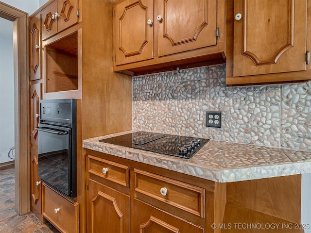 3504 E Haskell St, Tulsa, OK 74115 - kitchen featuring black appliances, decorative backsplash, brown cabinetry, and light countertops