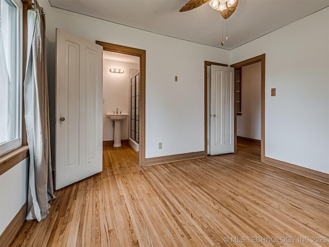 3504 E Haskell St, Tulsa, OK 74115 - unfurnished bedroom featuring light wood finished floors, baseboards, a sink, and connected bathroom