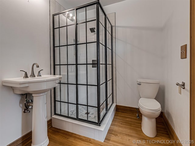 3504 E Haskell St, Tulsa, OK 74115 - bathroom with toilet, a shower stall, wood finished floors, and baseboards