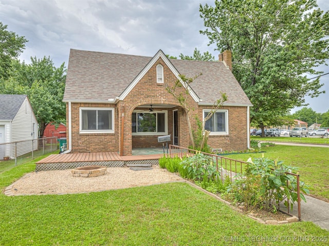 3504 E Haskell St, Tulsa, OK 74115 - english style home with brick siding, an outdoor fire pit, ceiling fan, a shingled roof, and a chimney