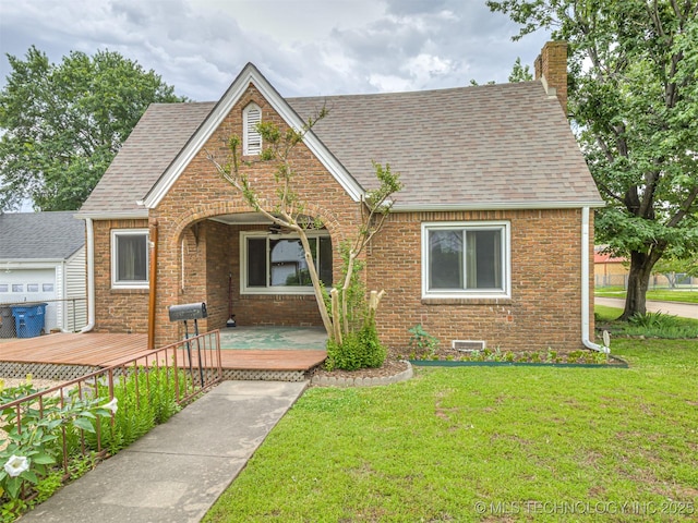 3504 E Haskell St, Tulsa, OK 74115 - english style home with a shingled roof, brick siding, a front yard, and a chimney