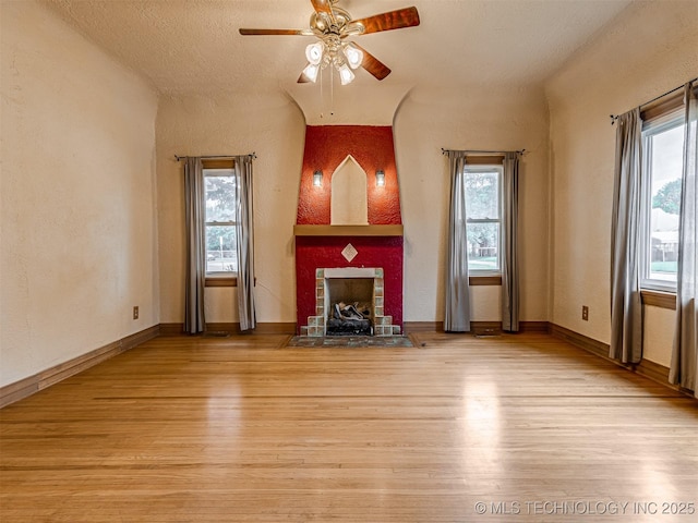 3504 E Haskell St, Tulsa, OK 74115 - unfurnished living room featuring a fireplace with flush hearth, healthy amount of natural light, and a ceiling fan