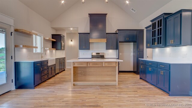 13801 N 54th E Ave, Collinsville, OK 74021 - kitchen with open shelves, stainless steel range with electric stovetop, blue cabinets, a sink, and light wood-type flooring