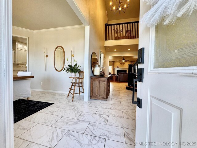 103 S Harrison Ave, Tahlequah, OK 74464 - foyer with light marble finish floors, crown molding, a chandelier, baseboards, and arched walkways
