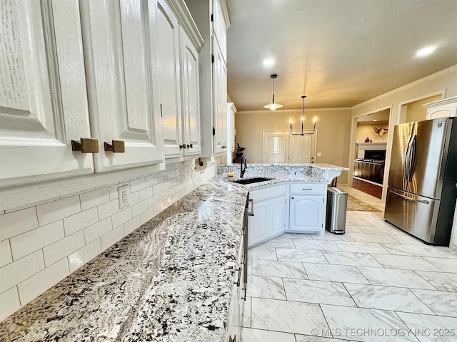 103 S Harrison Ave, Tahlequah, OK 74464 - kitchen featuring freestanding refrigerator, a sink, ornamental molding, a peninsula, and a fireplace