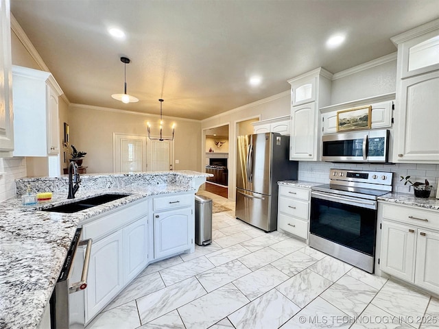 103 S Harrison Ave, Tahlequah, OK 74464 - kitchen with stainless steel appliances, a sink, ornamental molding, white cabinets, and pendant lighting