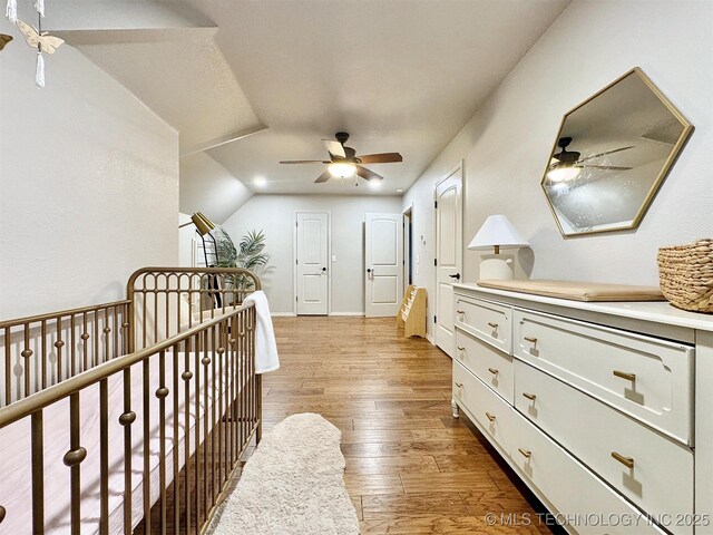 103 S Harrison Ave, Tahlequah, OK 74464 - bedroom with light wood-style flooring, ceiling fan, vaulted ceiling, a crib, and baseboards