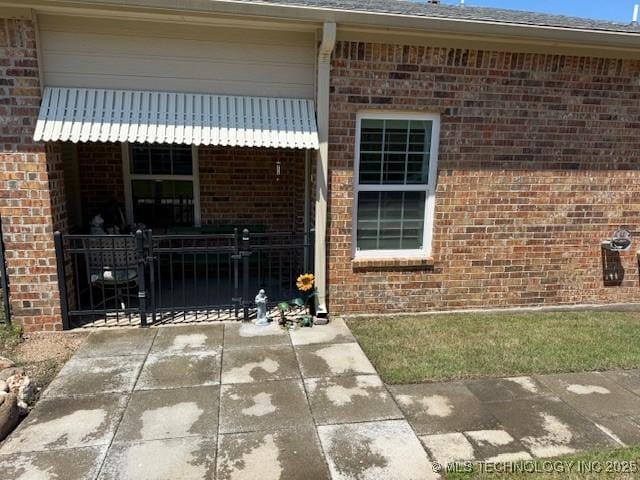 1620 Shenandoah Dr, Ardmore, OK 73401 - view of exterior entry with brick siding and a gate