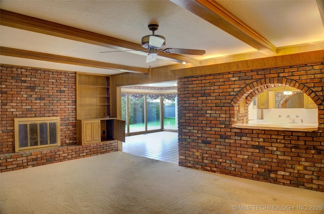 6788 E 66th Pl, Tulsa, OK 74133 - unfurnished living room featuring beam ceiling, carpet flooring, ceiling fan, wood walls, and a textured ceiling