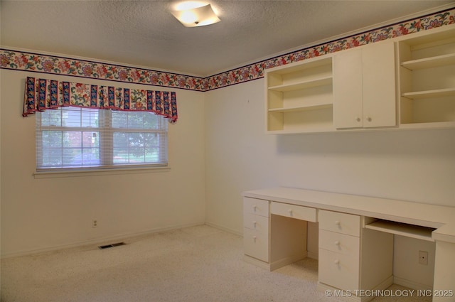 6788 E 66th Pl, Tulsa, OK 74133 - unfurnished office with a textured ceiling, built in desk, baseboards, and light colored carpet