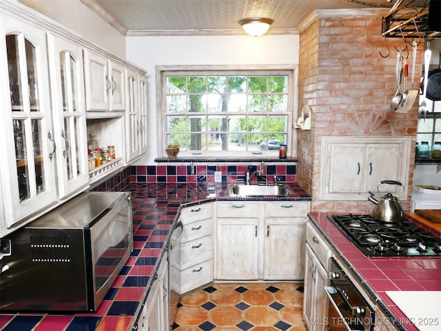 640 W 14th St, Tulsa, OK 74127 - kitchen with black gas stovetop, a sink, oven, tile counters, and ornamental molding