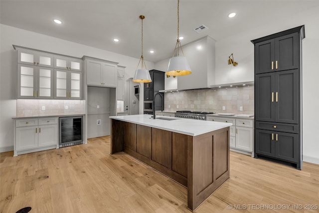 4127 S Cincinnati Ave, Tulsa, OK 74105 - kitchen with beverage cooler, a sink, backsplash, light countertops, and light wood-style floors