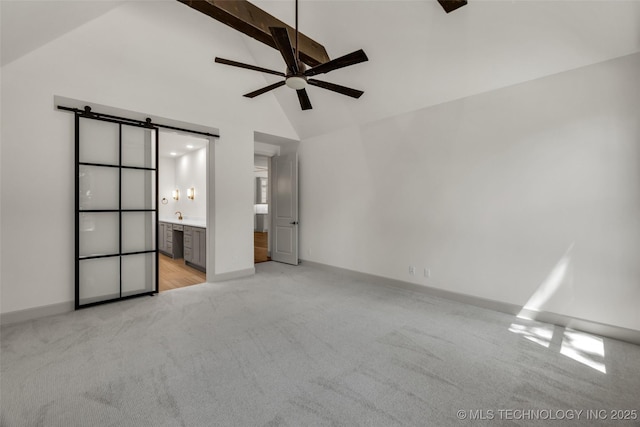 4127 S Cincinnati Ave, Tulsa, OK 74105 - unfurnished bedroom featuring light carpet, beamed ceiling, high vaulted ceiling, a barn door, and ensuite bathroom