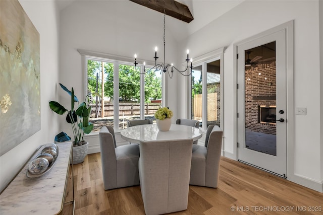 4127 S Cincinnati Ave, Tulsa, OK 74105 - dining room with light wood-type flooring, a chandelier, and a fireplace