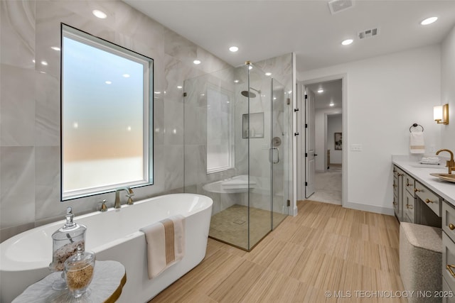 4127 S Cincinnati Ave, Tulsa, OK 74105 - bathroom with a shower stall, vanity, a freestanding bath, and recessed lighting