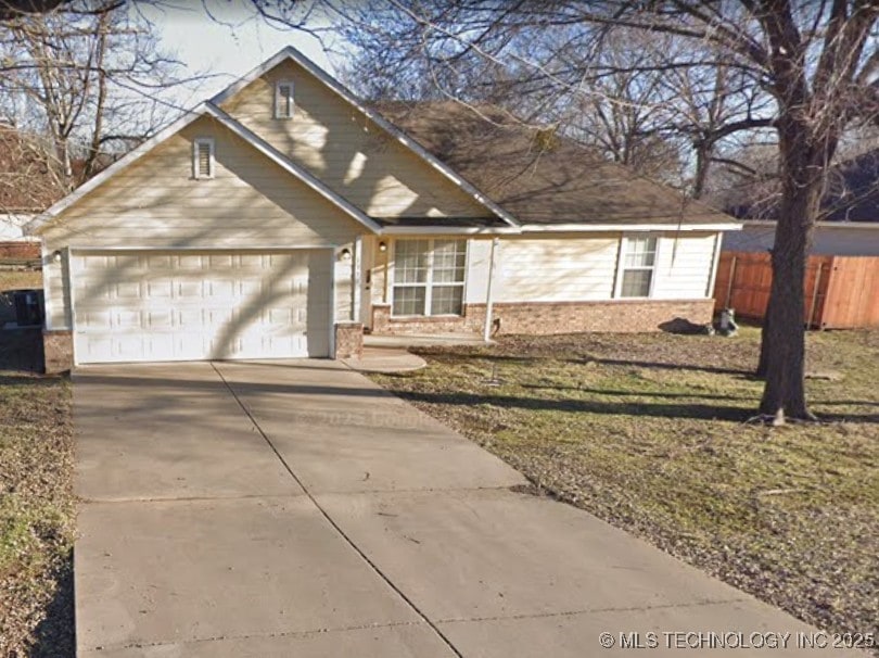 539 W Cherokee St, Sperry, OK 74073 - view of front of property with concrete driveway, an attached garage, and brick siding