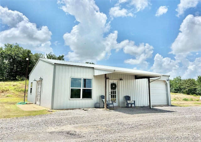 157 Canna Ln, Mcalester, OK 74501 - view of front facade with gravel driveway, a garage, and a metal roof