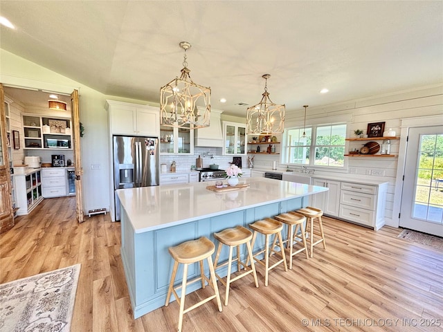 157 Canna Ln, Mcalester, OK 74501 - kitchen with open shelves, stainless steel fridge with ice dispenser, white cabinets, light wood-type flooring, and a chandelier