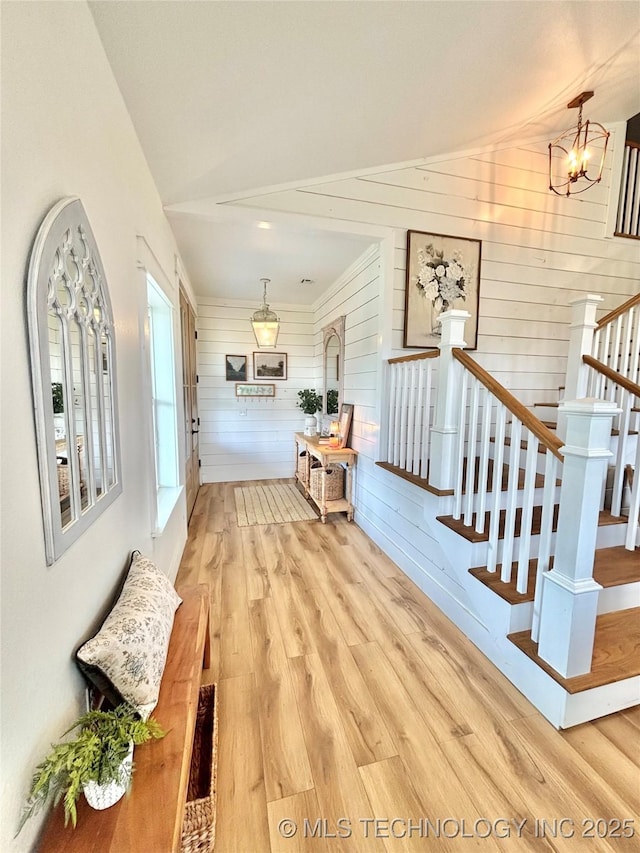 157 Canna Ln, Mcalester, OK 74501 - hallway featuring wood finished floors, lofted ceiling, a chandelier, stairway, and wooden walls