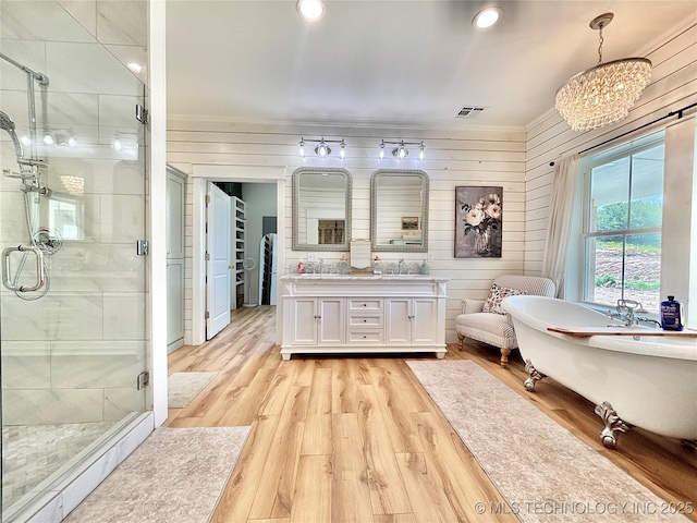 157 Canna Ln, Mcalester, OK 74501 - full bath with double vanity, a stall shower, a soaking tub, ornamental molding, and wood finished floors