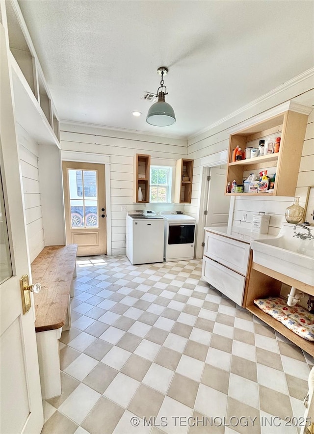 157 Canna Ln, Mcalester, OK 74501 - kitchen featuring open shelves, washer and clothes dryer, pendant lighting, wood walls, and light countertops