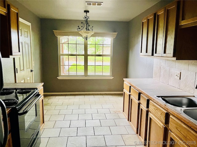 605 N Maple, Sallisaw, OK 74955 - kitchen featuring tile countertops, black range with electric stovetop, baseboards, and backsplash