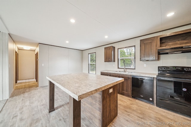 348939 E 750th Rd, Cushing, OK 74023 - kitchen featuring black appliances, under cabinet range hood, light wood-style flooring, light countertops, and a center island