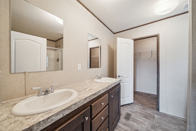 348939 E 750th Rd, Cushing, OK 74023 - bathroom featuring wood finished floors, double vanity, and a shower