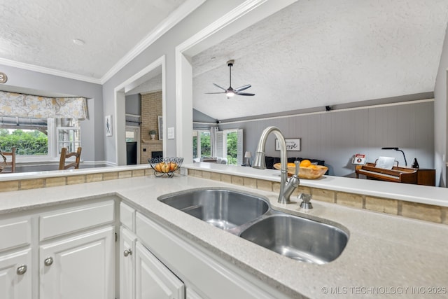 1209 Sherwood Ln, Broken Arrow, OK 74011 - kitchen with a sink, a textured ceiling, vaulted ceiling, white cabinets, and ceiling fan