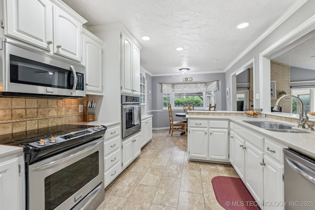 1209 Sherwood Ln, Broken Arrow, OK 74011 - kitchen with stainless steel appliances, a sink, plenty of natural light, white cabinets, and crown molding